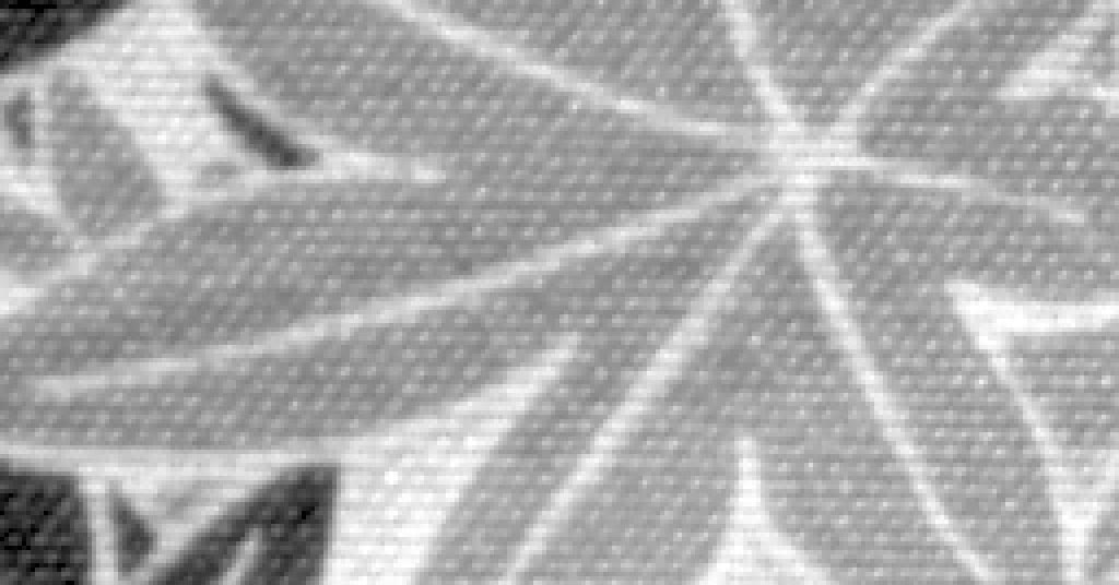 A crop of a photograph of patterned cloth, in grey, its noise visible